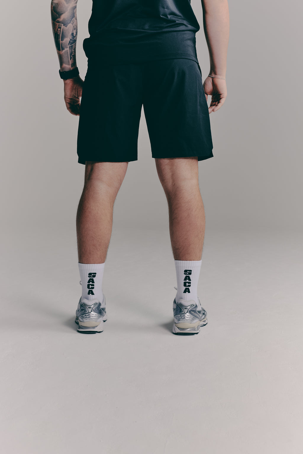 SACA Essential Shorts in black — side view worn by model